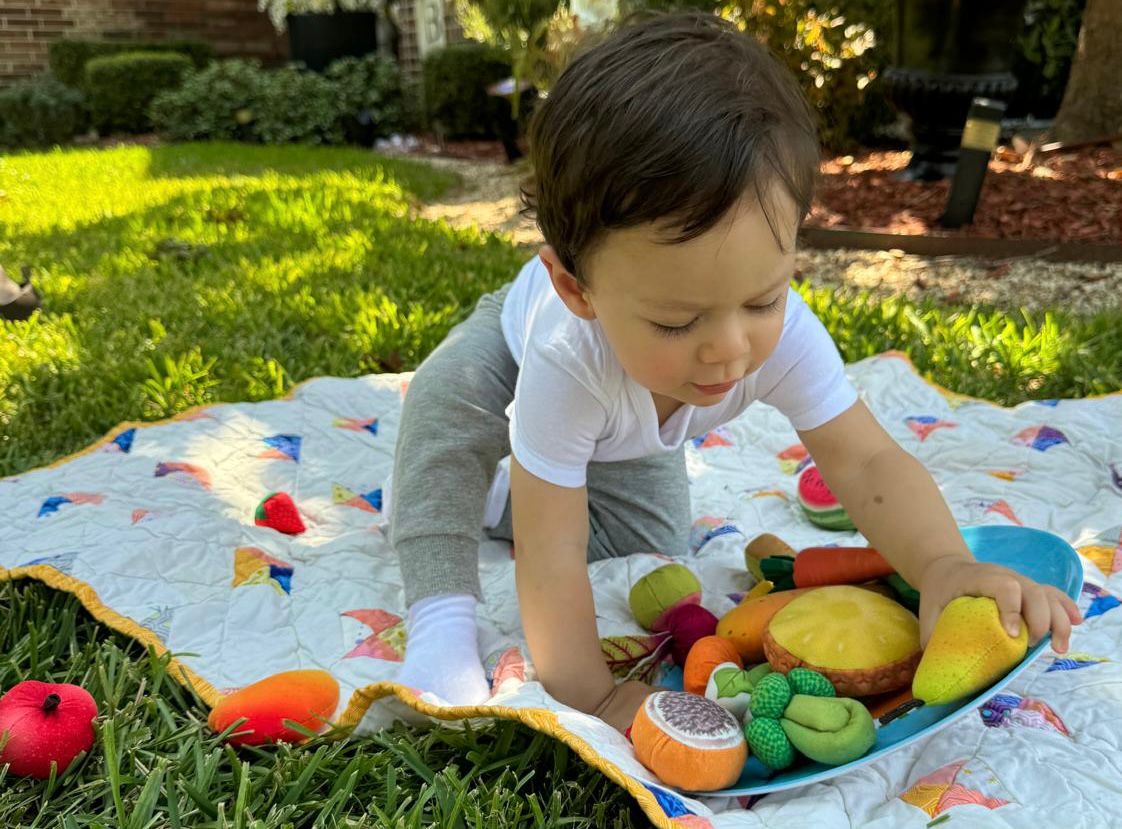 Niño explorando alimentos de juego durante una actividad de estimulación de la comunicación y la alimentación