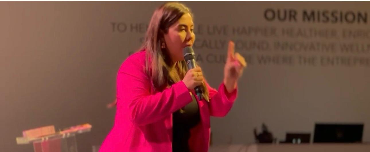 Juliana Pinto presentando con micrófono durante un taller para la comunidad